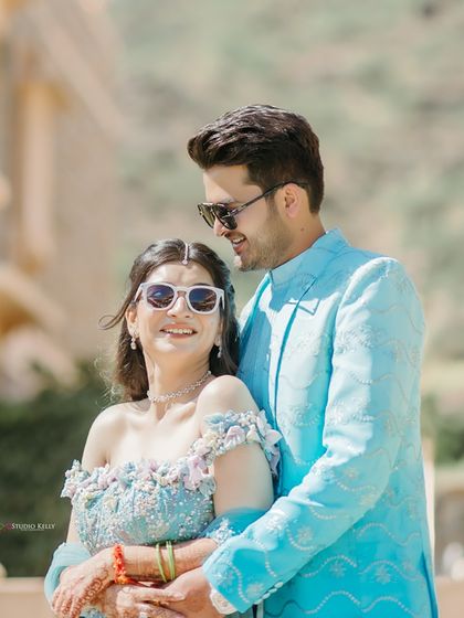 A close-up shot capturing the happy, relaxed smiles of the couple during their Pushkar palace shoot. Their sunglasses add a touch of modern fun to the elegant setting.