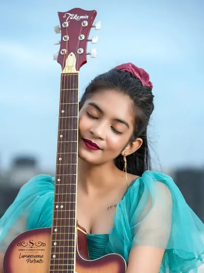 A moment of pure connection between the artist and her instrument, as she gently rests her face against the guitar.