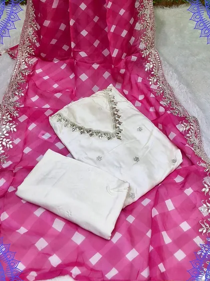 A classic white suit material with a vibrant pink and white checkered dupatta. The dupatta has a beautiful gota work border, making it a perfect festive choice.