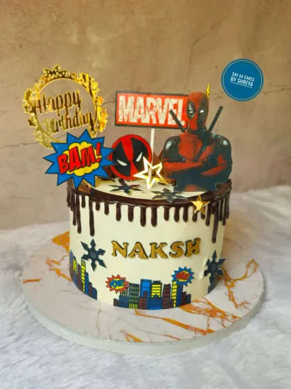 A Deadpool cake with maximum effort. This design captures the anti-hero's vibe with a chocolate drip, city skyline, and iconic Marvel and Deadpool logos, perfect for a fan's birthday.