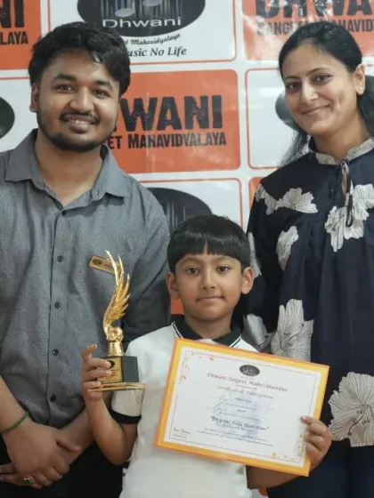 A student, his parent, and his teacher pose together with his award. This highlights the triangle of support between student, family, and our institute that fosters growth.