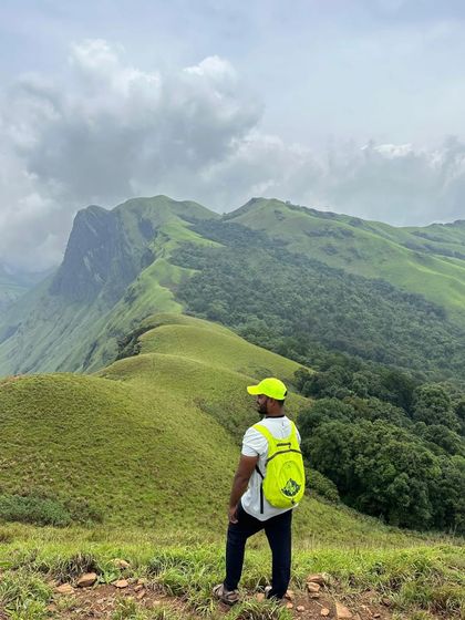 A trekker enjoying the panoramic view from the top. The feeling of being on top of the world is unmatched.