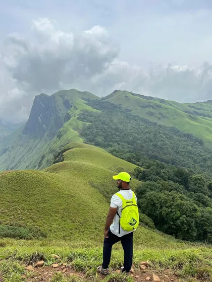 A trekker enjoying the panoramic view from the top. The feeling of being on top of the world is unmatched.