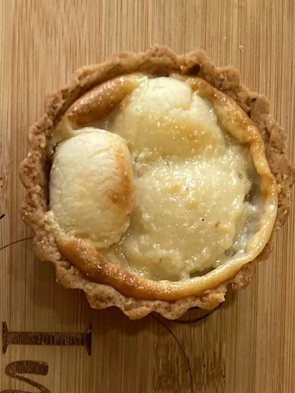 A close-up of my baked rasgulla tart. This is a unique fusion dessert, where the soft, syrupy rasgulla is baked into a creamy filling inside a crisp tart shell.