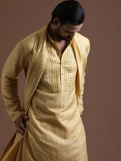 This Haldi outfit includes a matching stole with the textured kurta, adding a layer of sophistication and completing the ceremonial look.