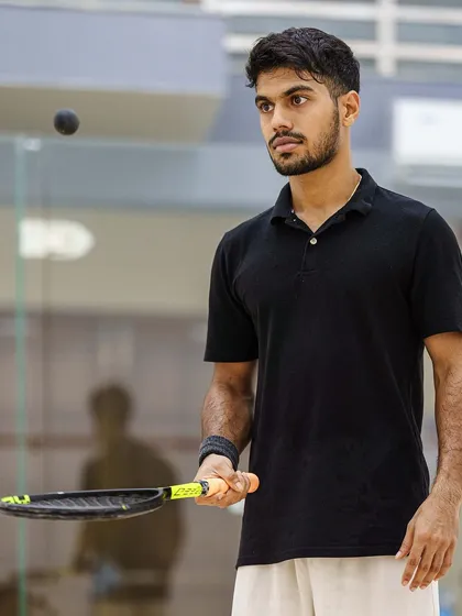 The calm before the storm. A squash player's intense concentration is palpable as he tracks the ball. I use lighting and focus to isolate the athlete, highlighting their mental game in the fast-paced environment of the glass court.