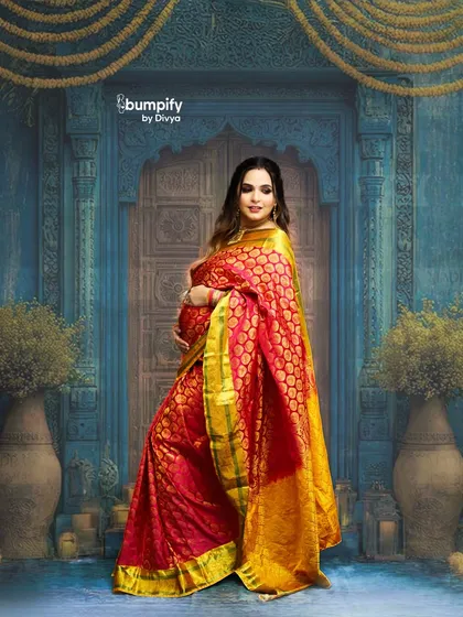 Celebrating motherhood with timeless tradition. This mom-to-be looks absolutely radiant in a vibrant red and gold Banarasi saree, posed against a classic, ornate blue doorway in my studio.