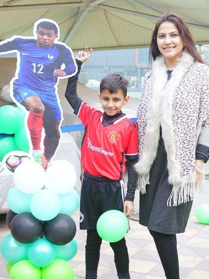 The birthday boy poses with a cutout of his favorite football player, part of the personalized party decor.
