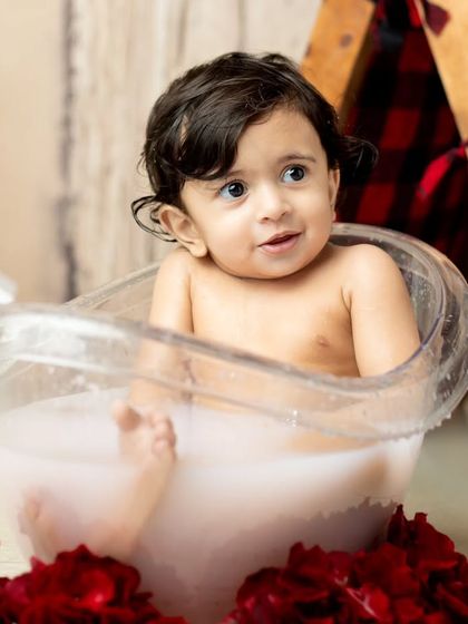 A close-up portrait of the baby enjoying the warm milk bath.