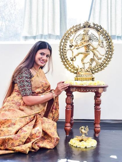 A smiling portrait next to the Nataraja idol, capturing my happiness on the day my dream studio became a reality.