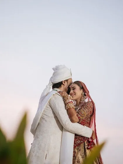 A sweet embrace against the evening sky. We plan for portrait sessions during the golden hour or twilight for the most romantic lighting.
