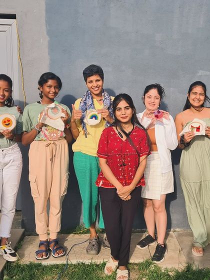 A happy group of crafters showing their finished punch needle pieces after a fun and productive workshop.