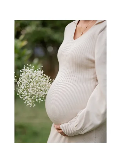 A classic baby bump photoshoot portrait, focusing on the beautiful shape and form of pregnancy. This elegant and simple shot was taken during an outdoor session, using natural elements to create a soft, timeless look.