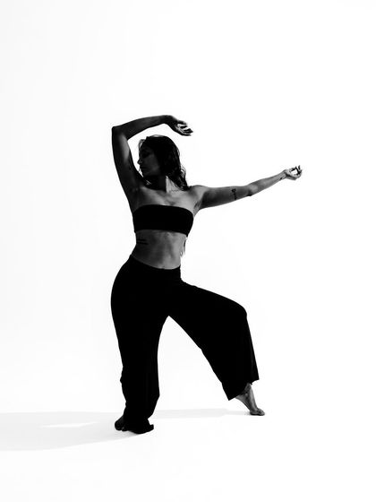 A full-body silhouette in black and white, emphasizing the strong lines and posture of the dance form.