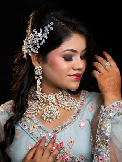 A close-up of a soft glam reception look. The focus is on the smokey eye, flawless skin, and the elegant hair accessory.