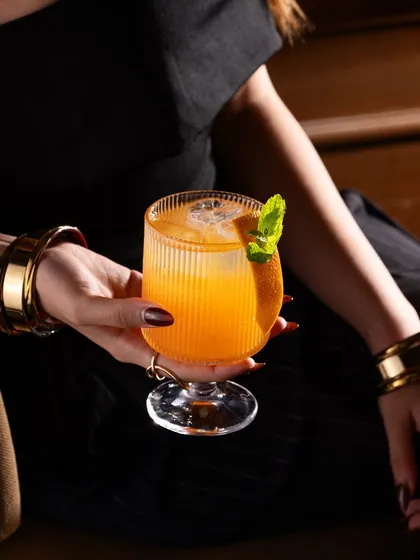 A lifestyle cocktail shot focusing on the guest's experience. Including a human element makes the drink feel more aspirational and connects with the customer.