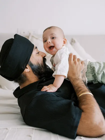 A playful moment between father and son during the seven-month session. The baby's laughter is contagious.