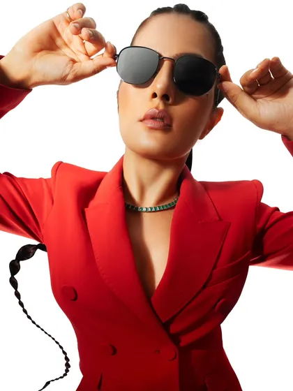 A confident close-up in a bold red suit. The sunglasses and direct gaze give the image a powerful, boss-like attitude, perfect for a modern workwear brand.