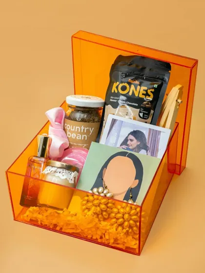 Another view of the trendy orange acrylic box for Rakhi. It's a modern and reusable gift box that makes the entire hamper feel premium and special.