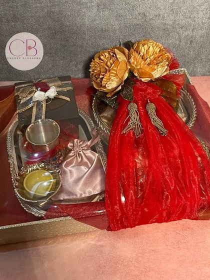 Another look at our Karwa Chauth sargi hamper. The trousseau packaging includes a silver thali set, a decorative sieve, and other traditional items, all beautifully wrapped.