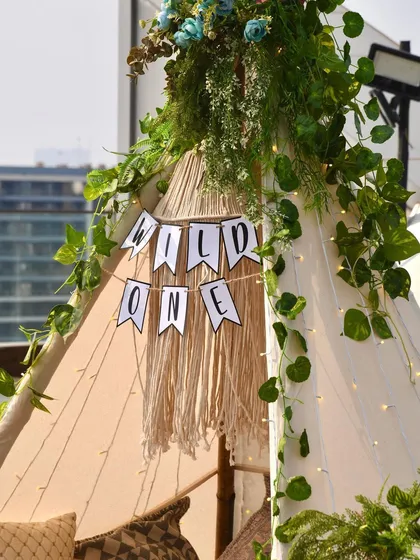The centerpiece of our "Wild One" party was this beautiful teepee tent, decorated with a "Wild One" banner, macrame details, and climbing ivy for a playful, adventurous feel.