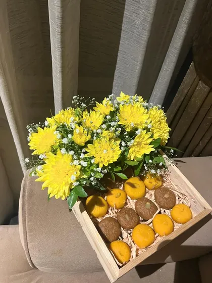 A wider view of our festive sweet tray, showing the simple wooden tray that holds both the fresh flowers and the delicious treats. It's a perfect, all-in-one gift.