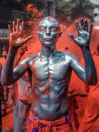 A silver-skinned alien figure covered in red powder during Holi. I love placing my sci-fi characters in traditional Indian festivals to see what happens.