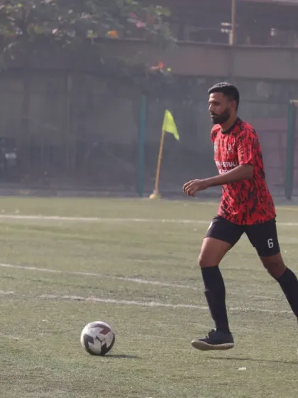 A senior team player controlling the midfield during the Republic Cup finals.