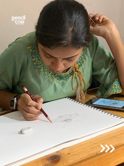 Another student is captured in the process of creation, carefully sketching her subject.