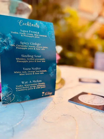 A closer look at the custom cocktail menu for Neville and Fariha's event, featuring drinks like 'Aqua Fresca' and 'Spicy Ginkgo'.