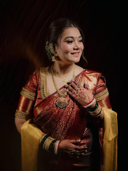 A stunning portrait of the bride, Ekta, glowing with happiness. The soft lighting highlights her beautiful smile and traditional wedding jewelry.