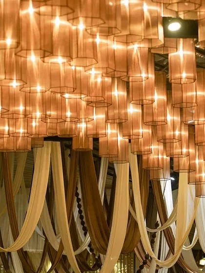 A different angle of the ceiling lamp installation, showing how it interacts with the draped fabrics below to create a cohesive and immersive overhead design.