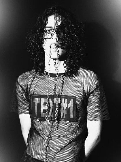 A creative portrait from a gothic-themed shoot, with chains obscuring the model's mouth. This black and white image is edgy, conceptual, and full of attitude.