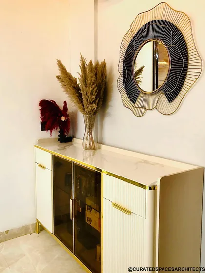 This elegant entryway console sets a sophisticated tone. The combination of white, gold, and glass, along with the decorative mirror, creates a welcoming and stylish first impression.