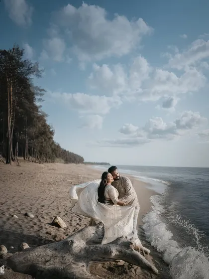 A breathtaking beach pre-wedding shot where the bride's dress flows in the wind, creating a sense of movement and romance against the ocean backdrop.