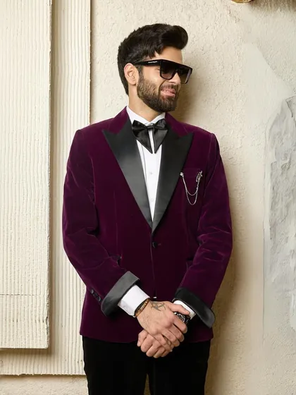 A confident pose in the wine velvet tuxedo. This image captures the essence of a man who is comfortable in his style and ready for any sophisticated occasion.