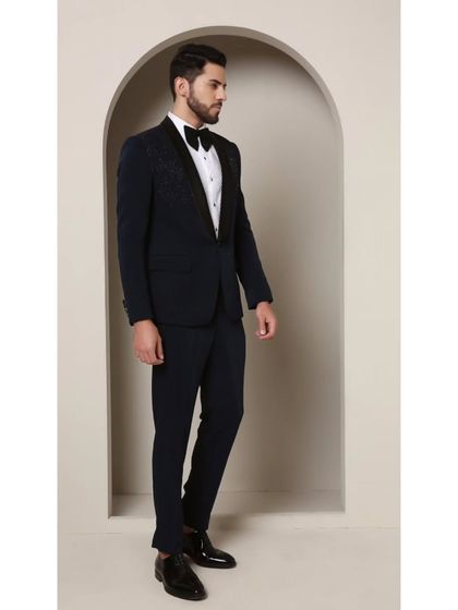 A full look at the Prism Riviera tuxedo. The geometric glass bead design on the upper chest of this teal jacket creates a brilliant, modern effect that contrasts beautifully with the classic satin shawl lapel.