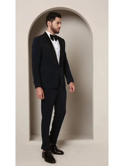 A full look at the Prism Riviera tuxedo. The geometric glass bead design on the upper chest of this teal jacket creates a brilliant, modern effect that contrasts beautifully with the classic satin shawl lapel.