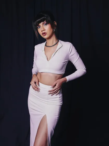A chic and modern look with a clean, dark backdrop. The all-white outfit contrasts beautifully, and the pose is perfect for showcasing a full look in a fashion portfolio.