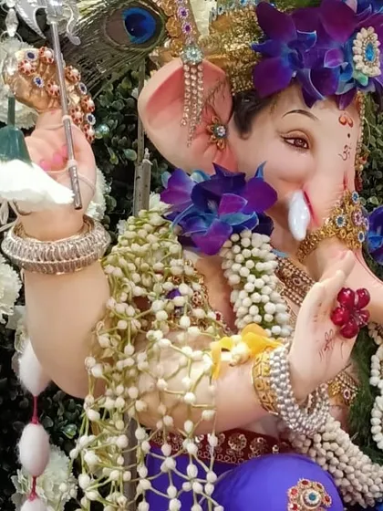 This is a close up of a custom Kanthi I made for Ganpati. It shows the fine details of the weaving, combining rich purple orchids with tiny, fragrant tagar flowers for a truly special design.