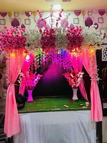 Here is another angle of the pink floral mandap, showing how it looks in a home setting. The grass base and elegant vases complete this ready-to-use decoration for a hassle-free celebration.