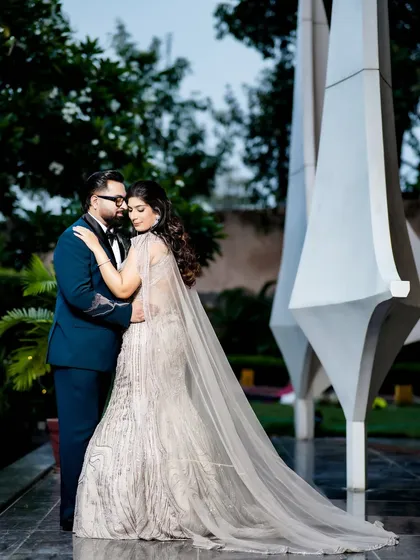 A romantic embrace in front of a modern sculpture, showing how I use unique backdrops for couple portraits.