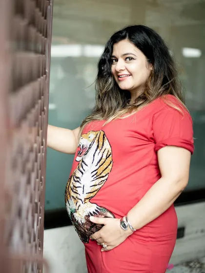 A confident solo portrait of the mom-to-be. Her pose and direct gaze radiate strength and happiness, celebrating her pregnancy with a bold and modern style.