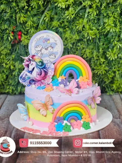 A whimsical unicorn and rainbow cake with butterfly accents. The pastel colours and multiple rainbows create a beautiful and enchanting birthday cake.