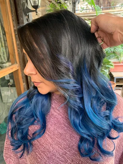 A side profile of the blue ombre hair. The color melts from a natural dark root into a beautiful, bright blue.