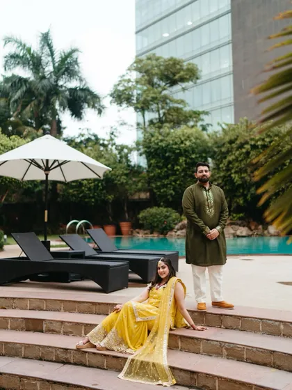 A relaxed portrait by the poolside during a mehndi event. The modern setting with the traditional outfits creates a unique and stylish pre-wedding photograph.