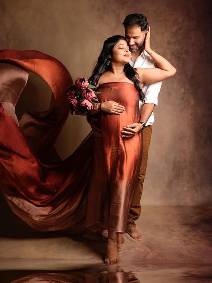 An elegant portrait featuring a flowing satin drape, capturing the couple in a moment of serene connection.