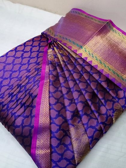 A deep purple saree with a mango motif pattern. The pleats are set, and the saree is ready to be draped flawlessly.