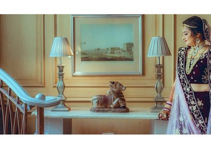 A classic bridal portrait using the elegant interior of the venue. The bride's pose is graceful, and the setting adds a touch of sophistication.