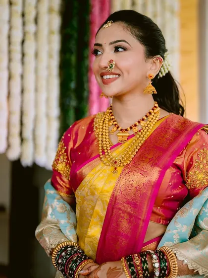 The joy on her face says it all. This look features a dewy base and a warm, smiling lip, perfect for a daytime Maharashtrian wedding ceremony.